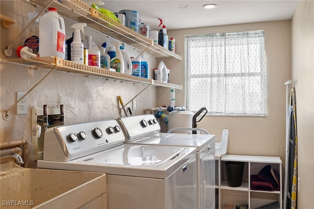 laundry area with washing machine and clothes dryer and sink