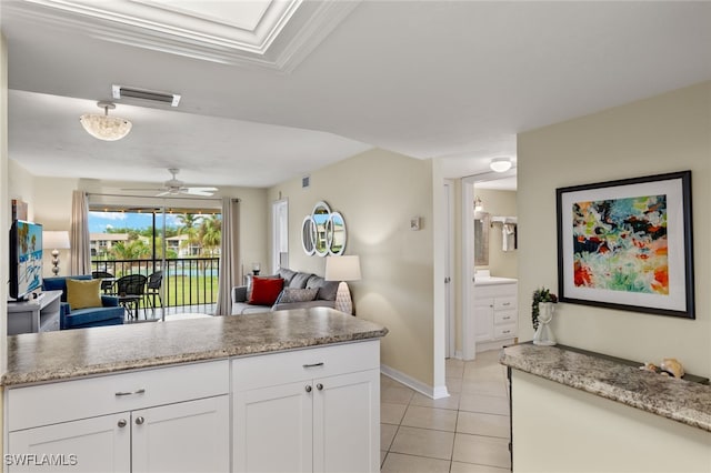 kitchen featuring white cabinetry, light tile patterned floors, light stone counters, and ceiling fan