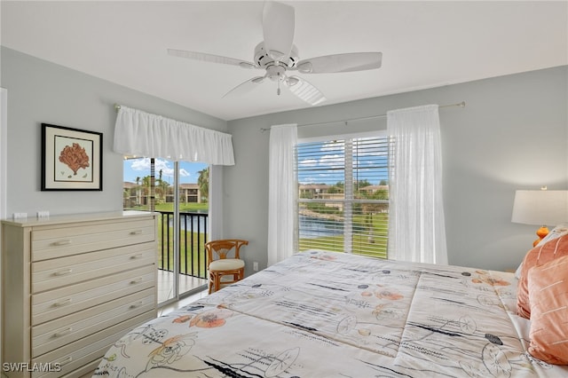 bedroom featuring multiple windows, ceiling fan, and a water view