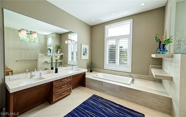 bathroom with vanity, a relaxing tiled tub, and tile patterned floors