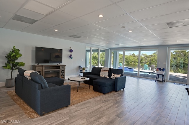 living room with a drop ceiling and light hardwood / wood-style floors