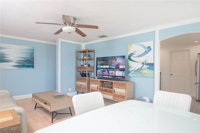 living room with wood-type flooring, ceiling fan, and crown molding