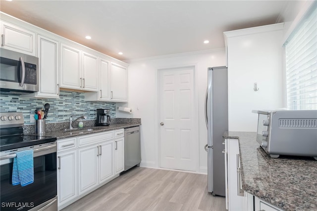 kitchen featuring white cabinetry, sink, light wood-type flooring, appliances with stainless steel finishes, and ornamental molding