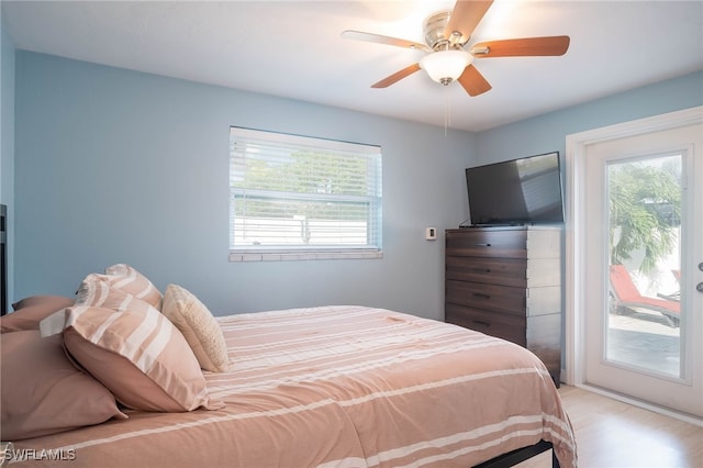 bedroom featuring access to outside, multiple windows, ceiling fan, and light wood-type flooring