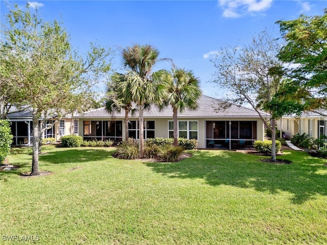 back of house with a sunroom and a yard