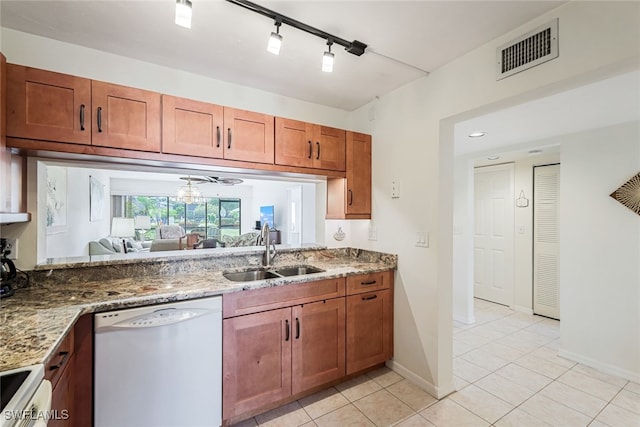 kitchen featuring white appliances, track lighting, sink, light stone countertops, and light tile patterned floors