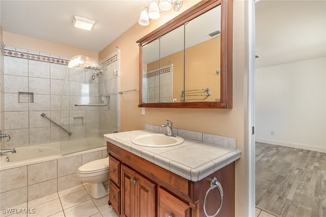 full bathroom with tiled shower / bath combo, toilet, wood-type flooring, and vanity