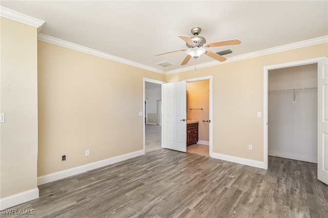 unfurnished bedroom featuring ensuite bath, ceiling fan, dark hardwood / wood-style flooring, a closet, and ornamental molding