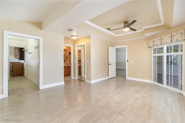 interior space with ceiling fan, light hardwood / wood-style floors, and a raised ceiling