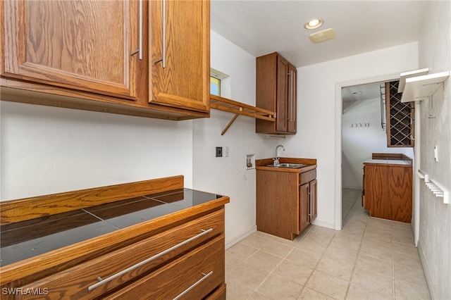 kitchen with tile counters, sink, and light tile patterned flooring