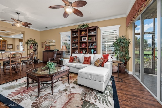 living area with ornamental molding, a ceiling fan, baseboards, and wood finished floors