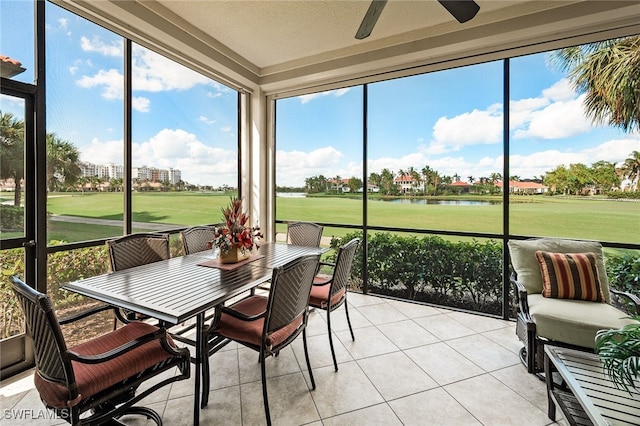 sunroom / solarium with a water view and ceiling fan