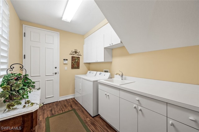 clothes washing area featuring dark wood-style flooring, washer and clothes dryer, cabinet space, a sink, and baseboards