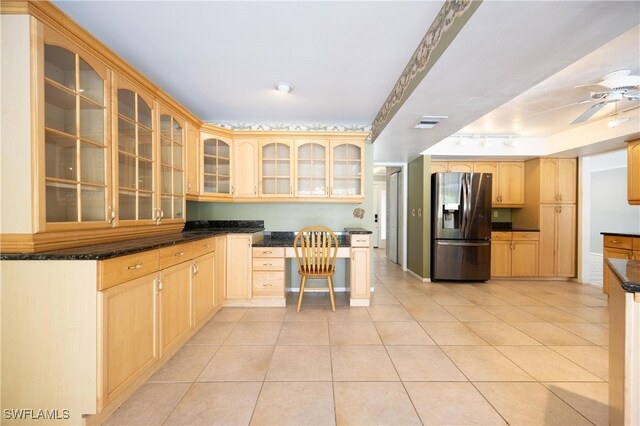 kitchen featuring stainless steel fridge with ice dispenser, built in desk, light brown cabinetry, and light tile patterned floors