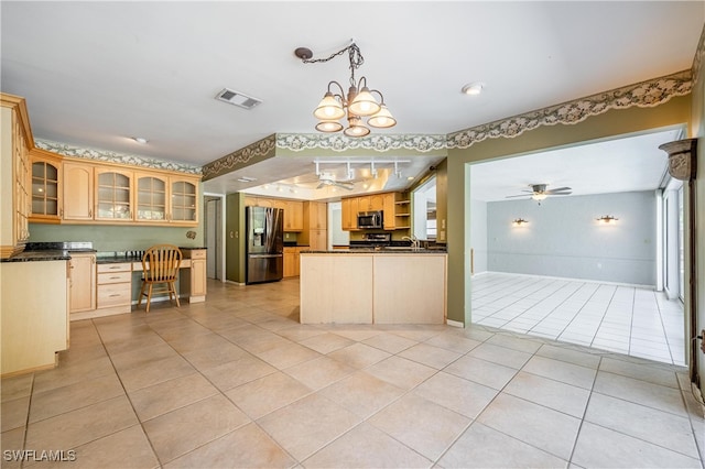 kitchen with pendant lighting, light brown cabinets, ceiling fan with notable chandelier, built in desk, and stainless steel appliances