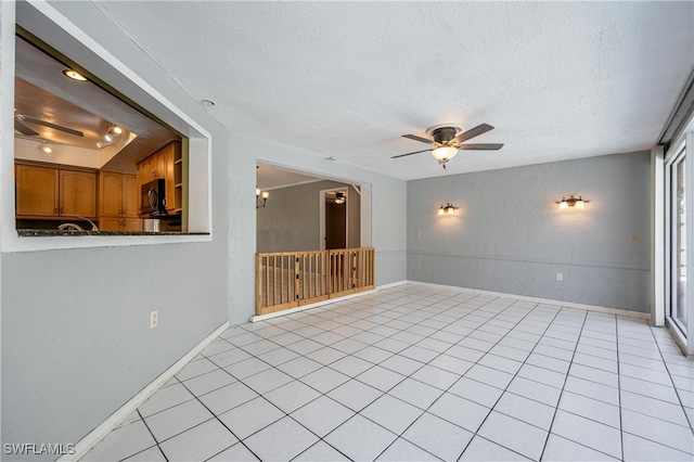 tiled spare room with ceiling fan and a textured ceiling