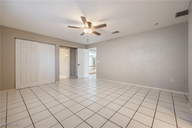 unfurnished bedroom with light tile patterned floors, a closet, and ceiling fan