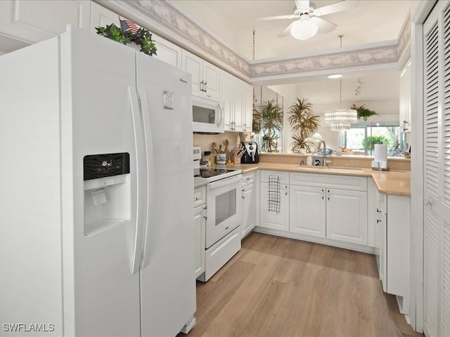 kitchen with ceiling fan with notable chandelier, white cabinetry, sink, light hardwood / wood-style floors, and white appliances