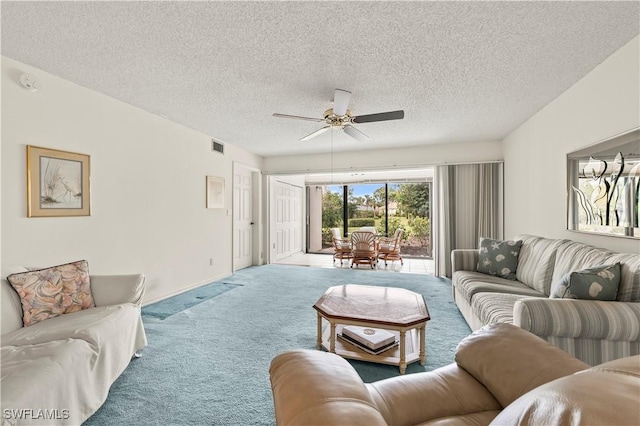 living room featuring ceiling fan, a textured ceiling, and carpet flooring