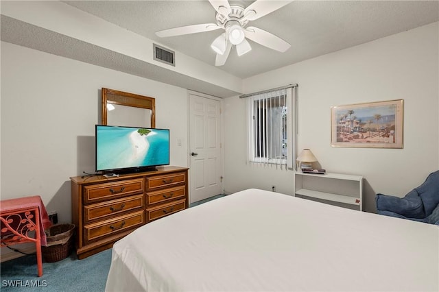 bedroom featuring a textured ceiling, ceiling fan, and light colored carpet