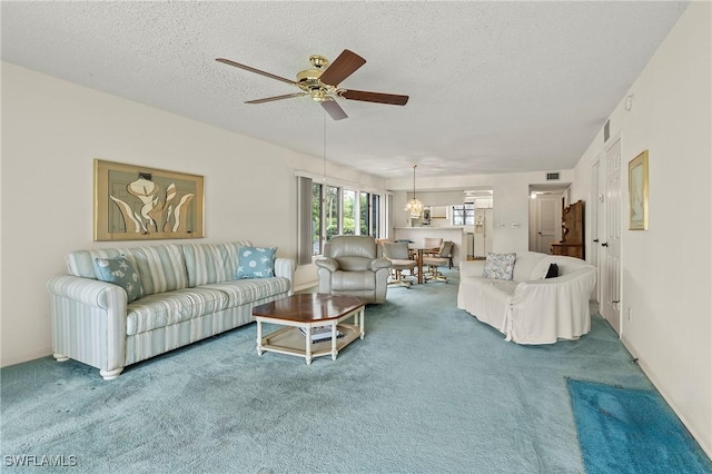 carpeted living room featuring a textured ceiling and ceiling fan