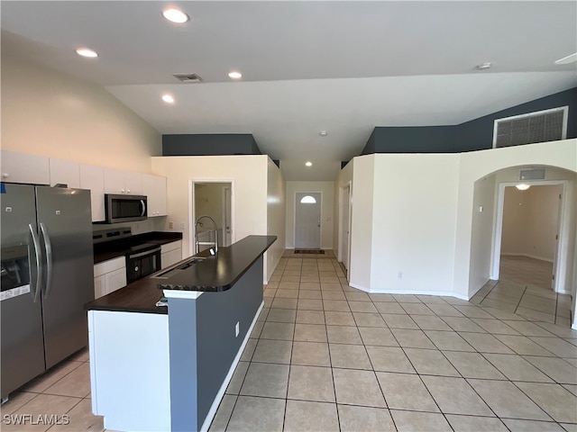 kitchen featuring white cabinetry, sink, an island with sink, light tile patterned floors, and appliances with stainless steel finishes