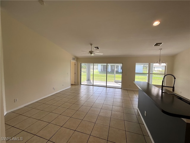 unfurnished living room featuring light tile patterned floors and ceiling fan with notable chandelier