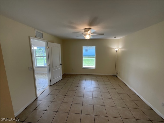 tiled empty room with ceiling fan