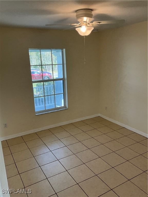 tiled empty room featuring ceiling fan