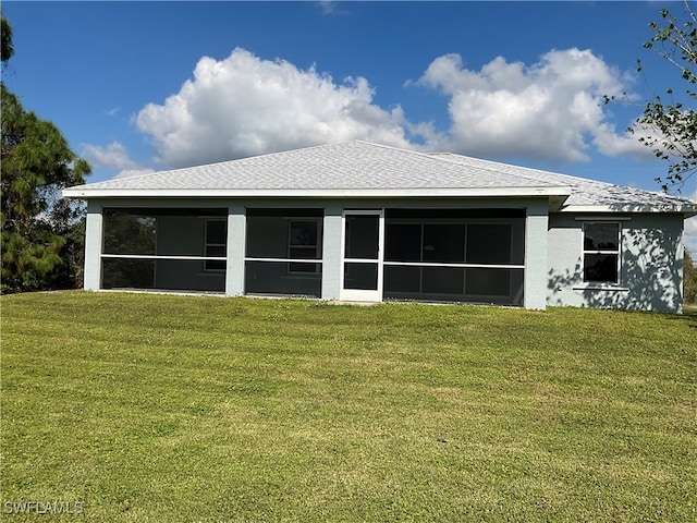 back of house featuring a lawn and a sunroom