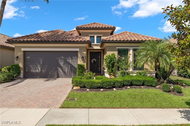 mediterranean / spanish-style home featuring a garage and a front yard