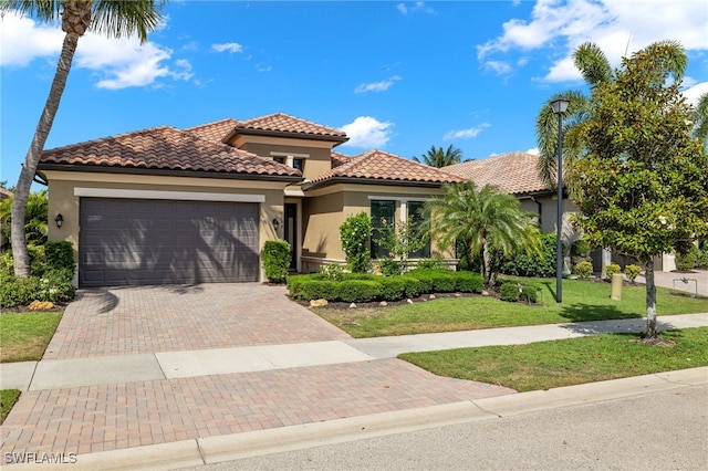 mediterranean / spanish-style home with a garage and a front yard