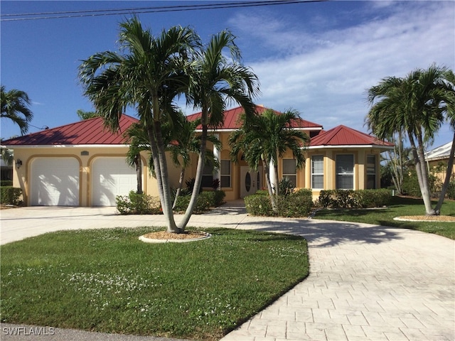 mediterranean / spanish-style house featuring a garage and a front lawn