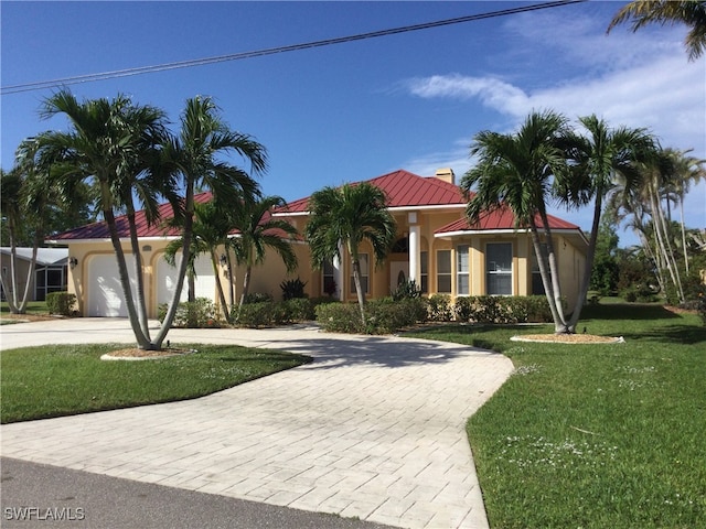 mediterranean / spanish-style home featuring a front yard and a garage