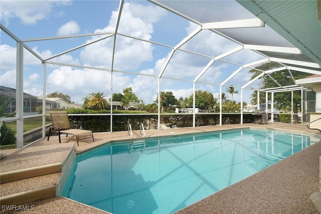 view of swimming pool featuring a patio and a lanai