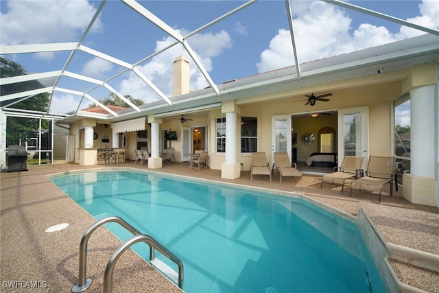 view of pool with ceiling fan, a patio, and a lanai