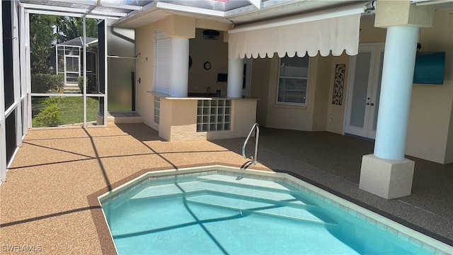 view of swimming pool with a patio area and a lanai