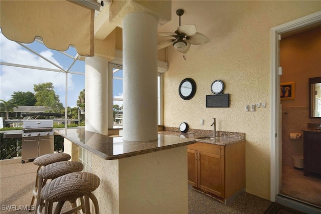 view of patio with ceiling fan, grilling area, a lanai, and a wet bar