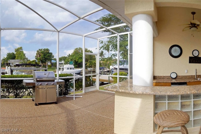 view of patio featuring a lanai, area for grilling, and ceiling fan