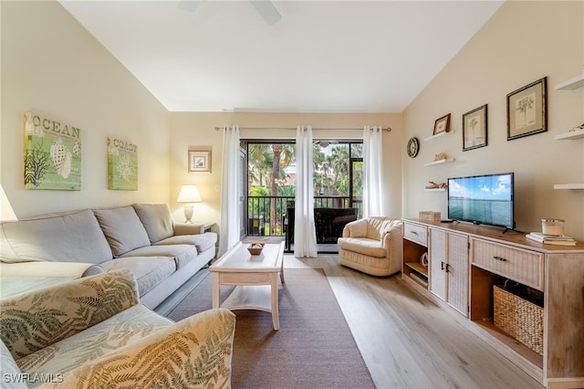 living room with light hardwood / wood-style floors and vaulted ceiling