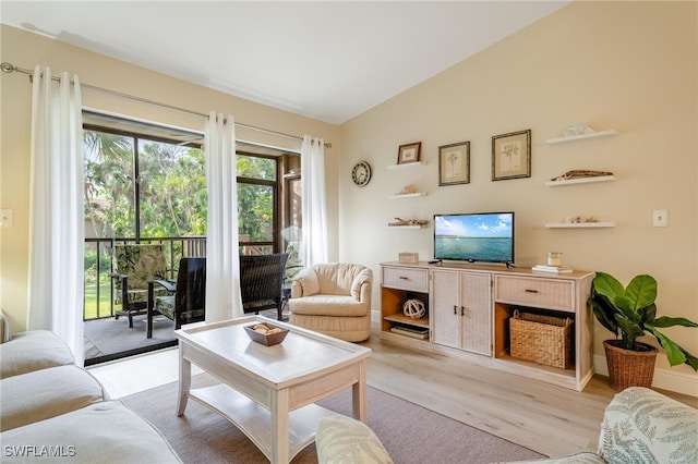 living room featuring vaulted ceiling and light hardwood / wood-style flooring