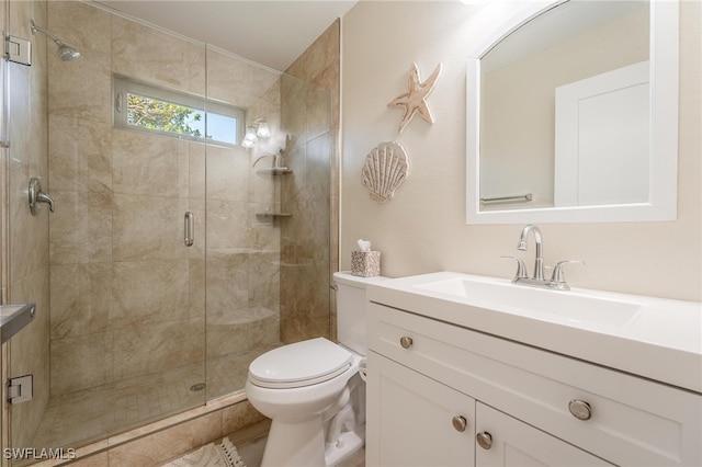 bathroom featuring vanity, a shower with shower door, and toilet