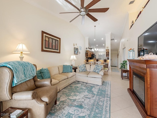 living room featuring ceiling fan with notable chandelier, light tile patterned floors, and lofted ceiling