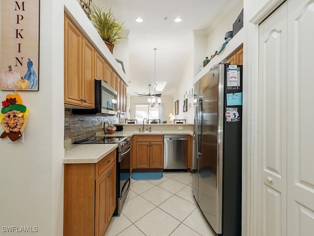 kitchen with pendant lighting, sink, light tile patterned floors, tasteful backsplash, and stainless steel appliances