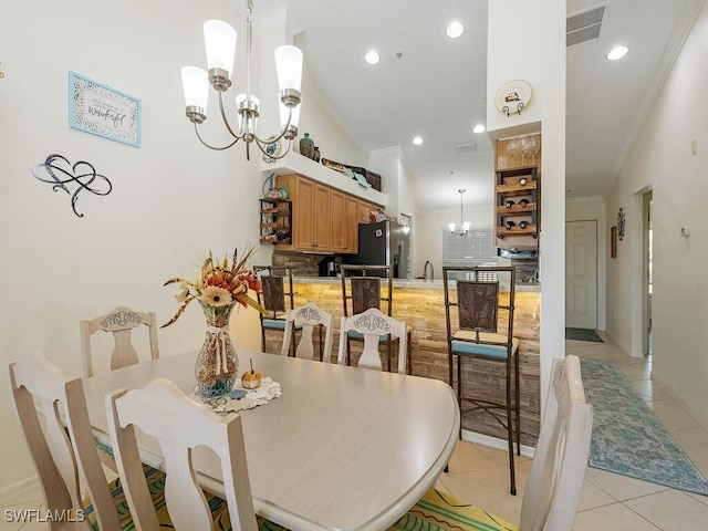 dining area featuring crown molding, sink, light tile patterned floors, and lofted ceiling