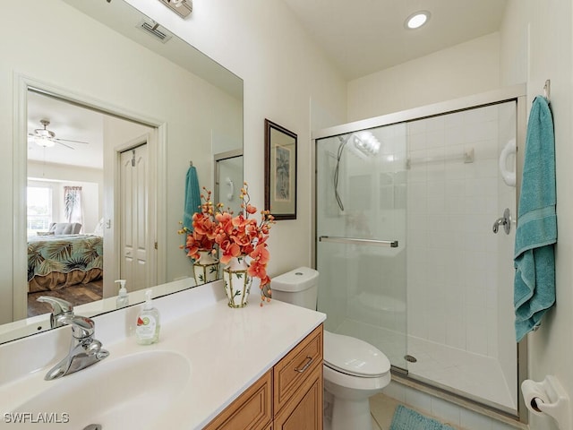 bathroom featuring tile patterned floors, vanity, a shower with shower door, and toilet