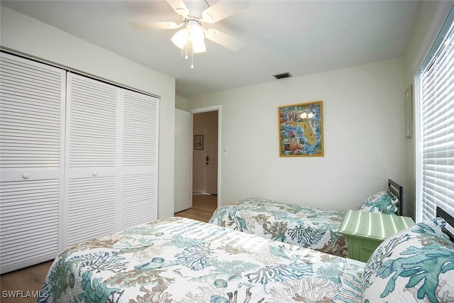 bedroom with hardwood / wood-style flooring, a closet, and ceiling fan