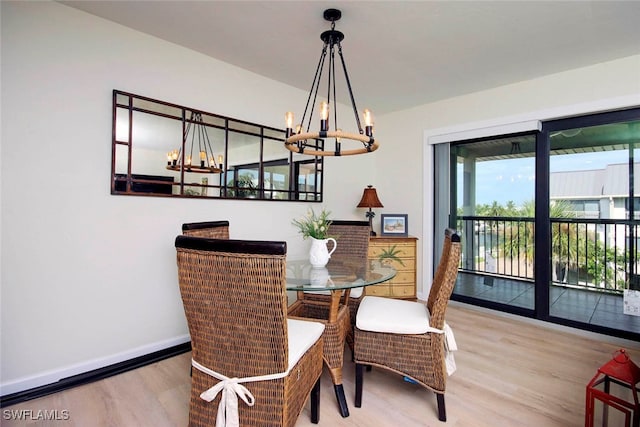 dining space featuring wood-type flooring and an inviting chandelier