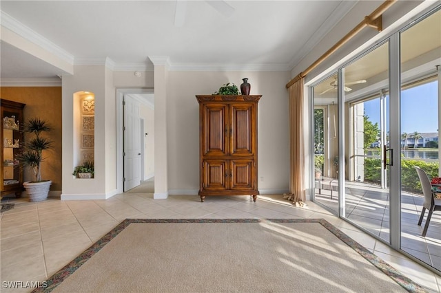 tiled empty room featuring ceiling fan and crown molding