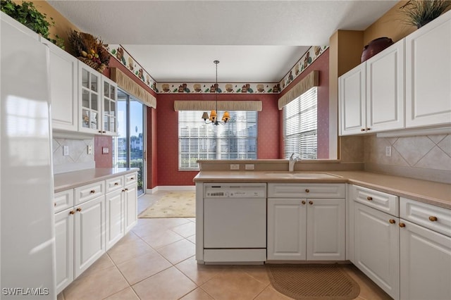 kitchen with dishwasher, sink, hanging light fixtures, decorative backsplash, and white cabinetry